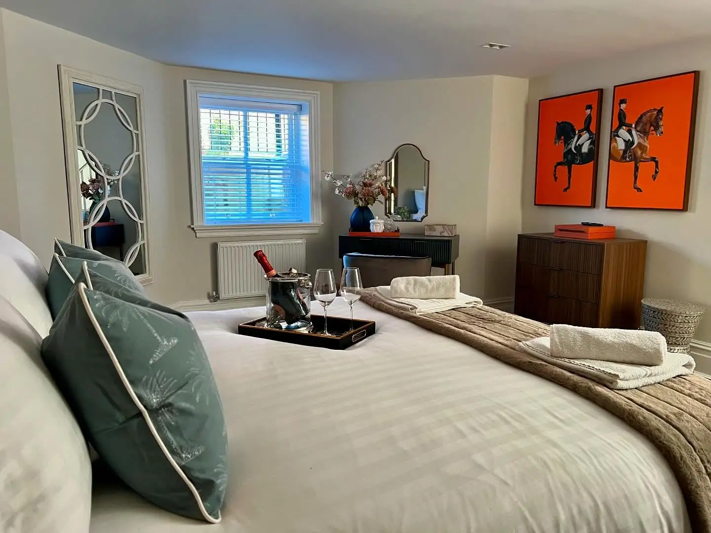 Bedroom with orange equestrian prints and a dressing table