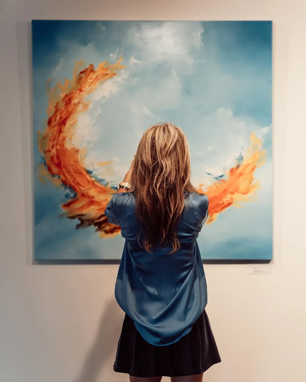 Dannielle standing in front of one of her paintings at the Baobab Suites exhibition