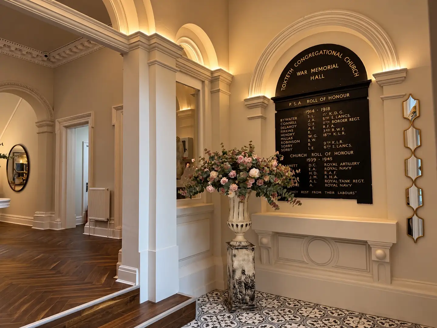 Roll of honour board, uplit, with a floral arrangement on patterned tiles